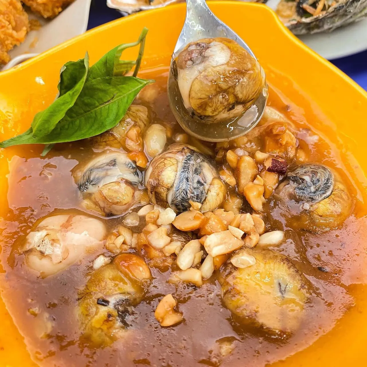 Chảo trứng cút lộn đang được xào đều trong nước sốt me sánh mịn, thơm lừng