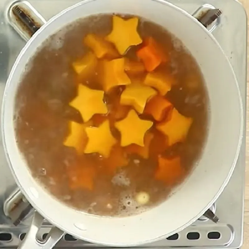 Canh đang được hầm ở lửa vừa để bí đỏ chín dẻo tự nhiên