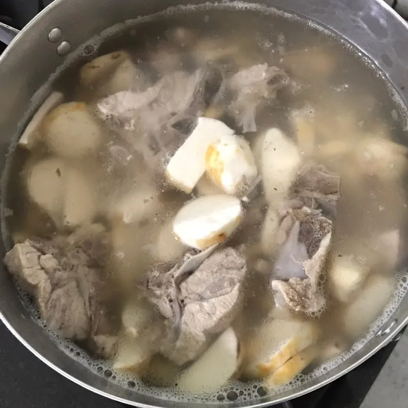 Đổ khoai sọ vào nồi canh đã hầm xương