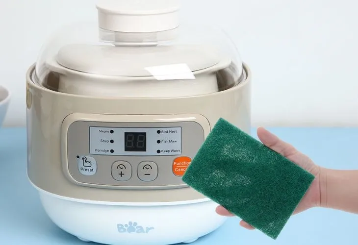 Vệ sinh nắp nồi nấu chậm bằng miếng rửa chén