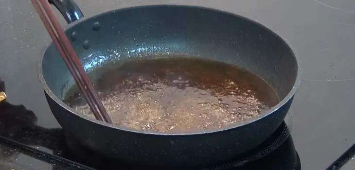 Đảo gà trong nước sốt mè để thấm đều gia vị