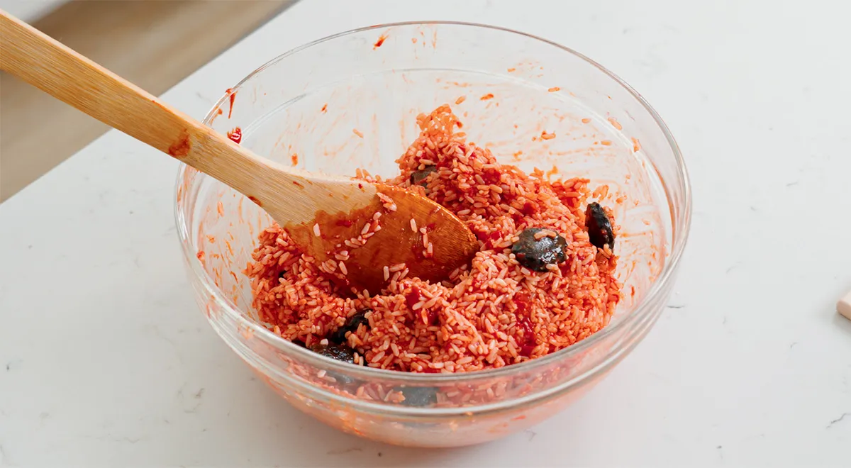 Trộn đều gạo nếp với thịt gấc để tạo màu đỏ bắt mắt