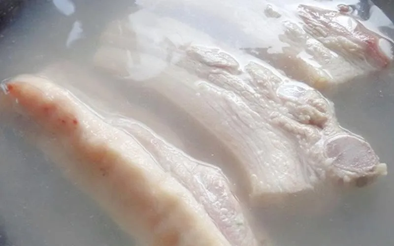 Cách xử lý chần nước sôi để loại bỏ tạp chất trong thịt heo.