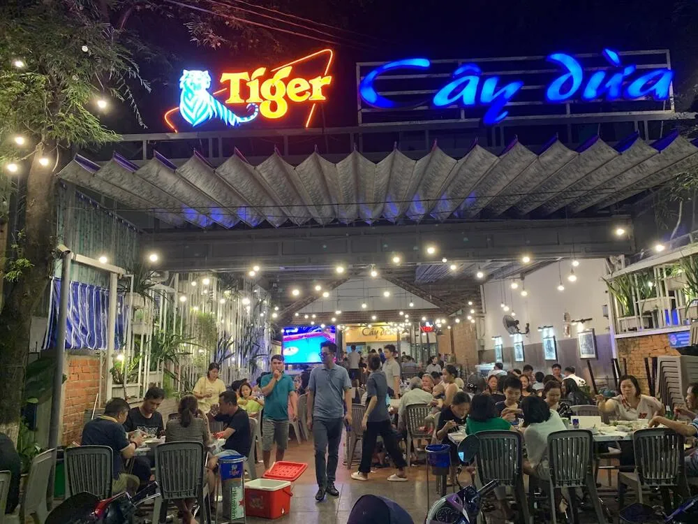 Không gian quán Cây Dừa 33 Nguyễn Huệ với bàn ghế gỗ tự nhiên, view hướng biển