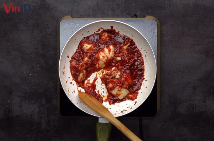 Xào kim chi cùng gia vị giúp nước lẩu có màu đỏ óng ả