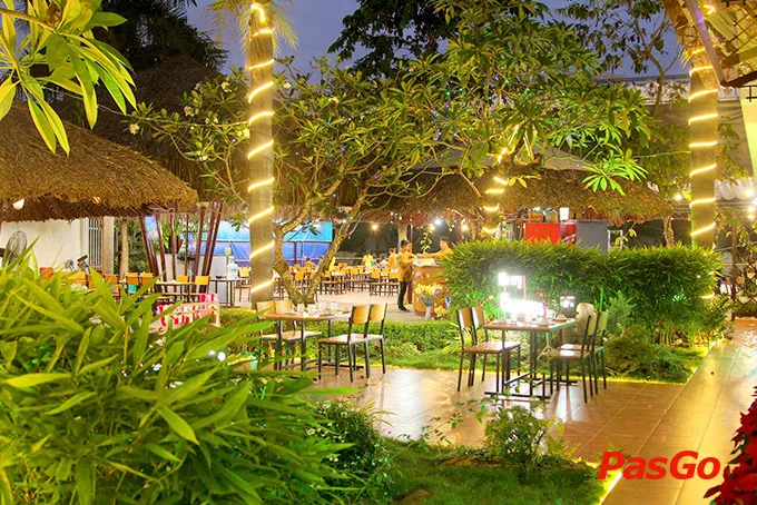 Không gian sân vườn thoáng mát tại Ẩm Thực Sân Vườn Mái Lá với ao cá và cây xanh