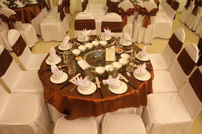 Bàn tiệc được bày biện tinh tế với bộ đồ ăn sứ trắng cao cấp