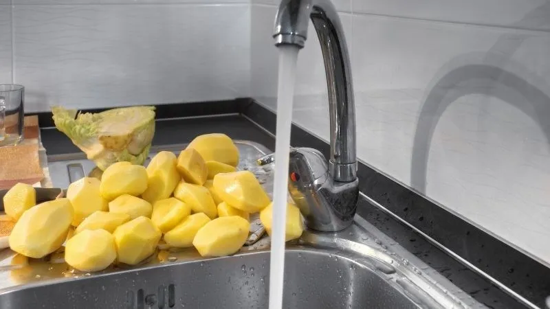 Rửa sạch khoai tây với nước cho hết nhựa