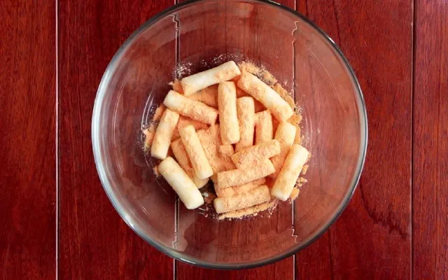 Lắc đều tay để bột phô mai bao phủ bánh