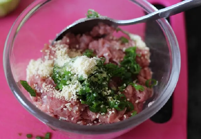 Ướp thịt băm với gia vị và hành tím băm nhuyễn