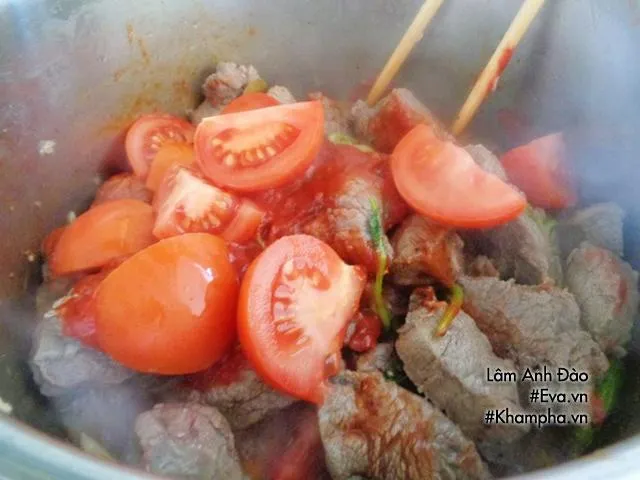 Thịt bò đang được xào săn cùng với các loại gia vị và hành tỏi băm trong nồi lớn trước khi hầm nước dừa