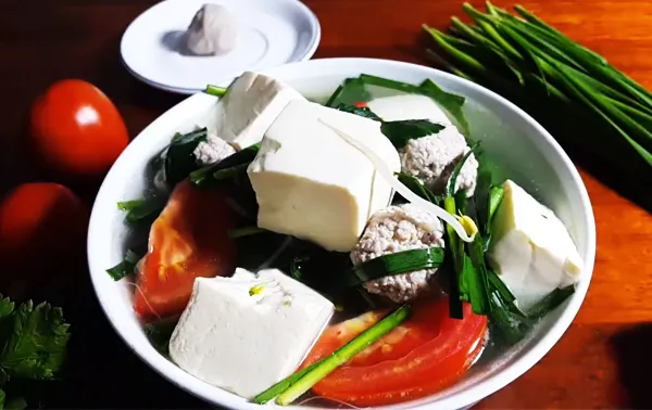 Tô canh hẹ đậu hũ cà chua nóng hổi với tiêu rắc trên mặt