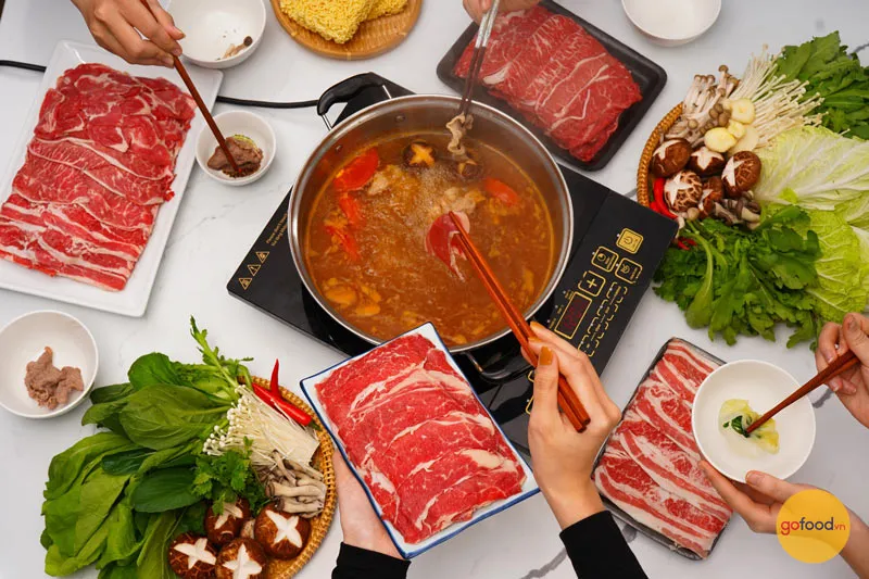 Nhúng thịt bò vào nồi lẩu nóng hổi cho bữa tiệc gia đình