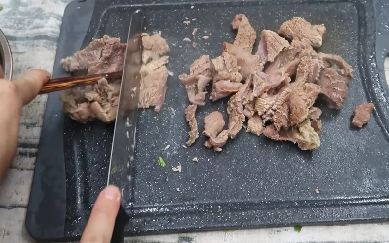 Cắt gân bò thành miếng vừa ăn sau khi đã hầm mềm