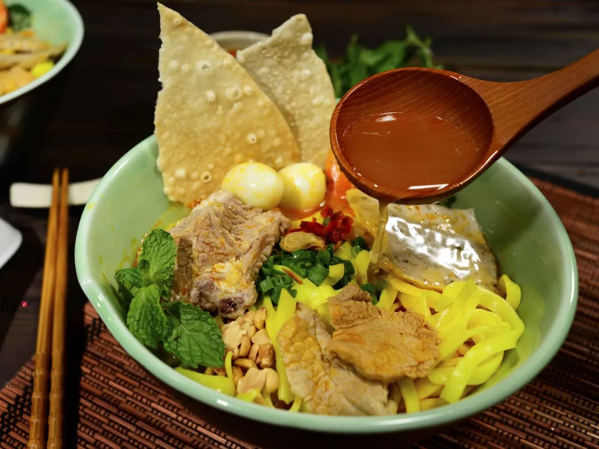 Bát mì quảng gà hoàn chỉnh với đầy đủ các loại gia vị và rau ăn kèm