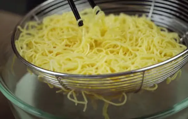 Trụng sợi mì trứng cho món mì vịt tiềm
