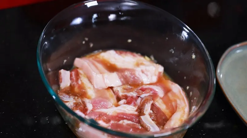 Thịt ba chỉ được trộn đều cùng nước sốt để đảm bảo từng miếng thịt đều đậm đà