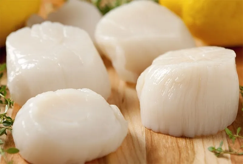 Hình ảnh các nguyên liệu sò điệp tươi, cà rốt và các loại rau gia vị đang được sơ chế