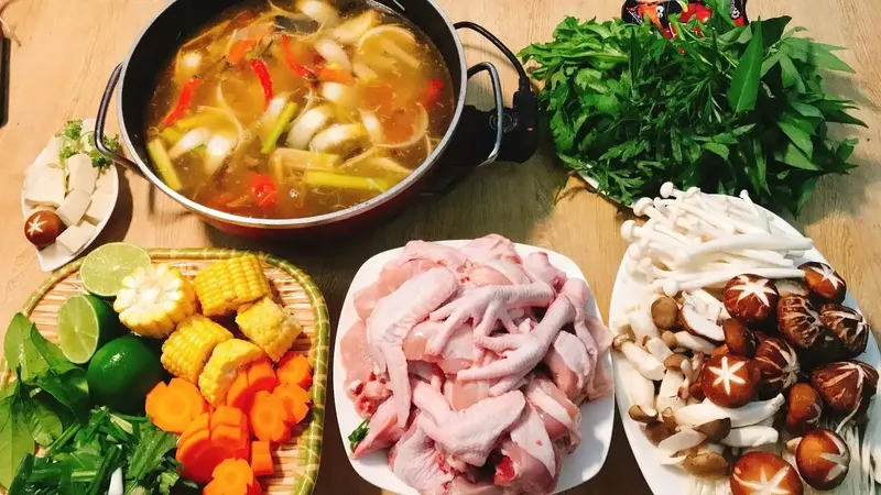 Mâm lẩu gà thập cẩm đầy đủ nấm và rau xanh