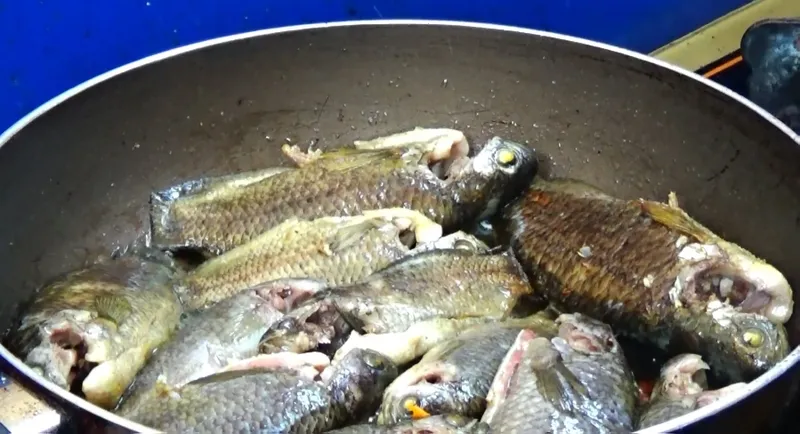 Cá rô đang được kho trên bếp với lửa nhỏ