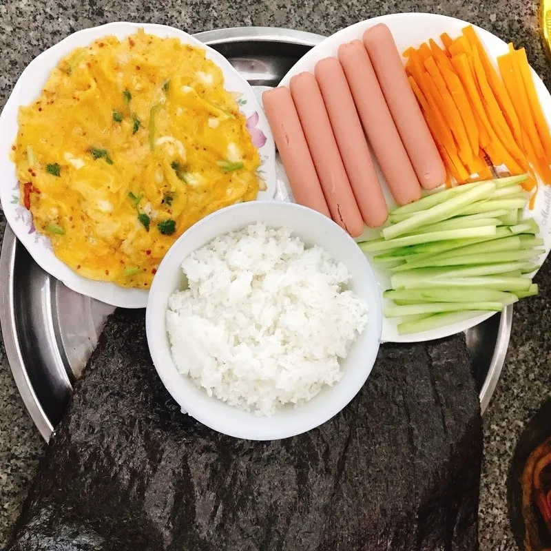 Dàn đều cơm lên lá rong biển và sắp xếp nhân ở chính giữa để cuộn được cân đối