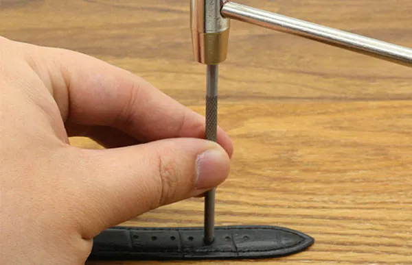 Thao tác sử dụng búa với dụng cụ đục lỗ dây đồng hồ