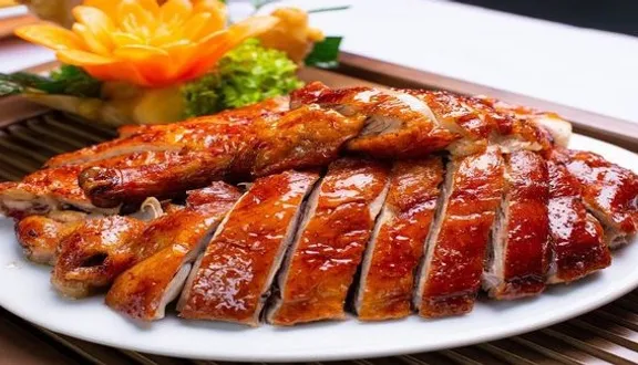 Món vịt nướng được chặt miếng đều đặn, phục vụ kèm bát nước chấm chuẩn vị