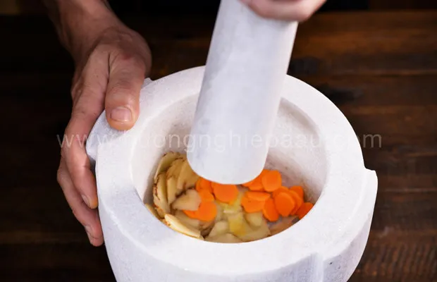 Nghệ và riềng được giã nhuyễn chuẩn bị cho việc ướp thịt