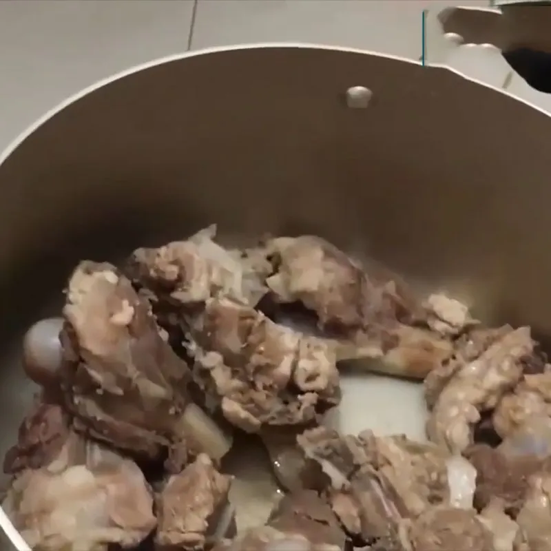 Nồi nước dùng xương heo đang được ninh trên bếp lửa nhỏ