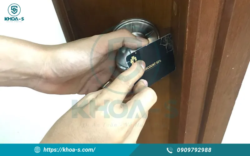 Tìm khe hở giữa cánh cửa và khung, nhét thẻ vào vị trí có chốt lò xo