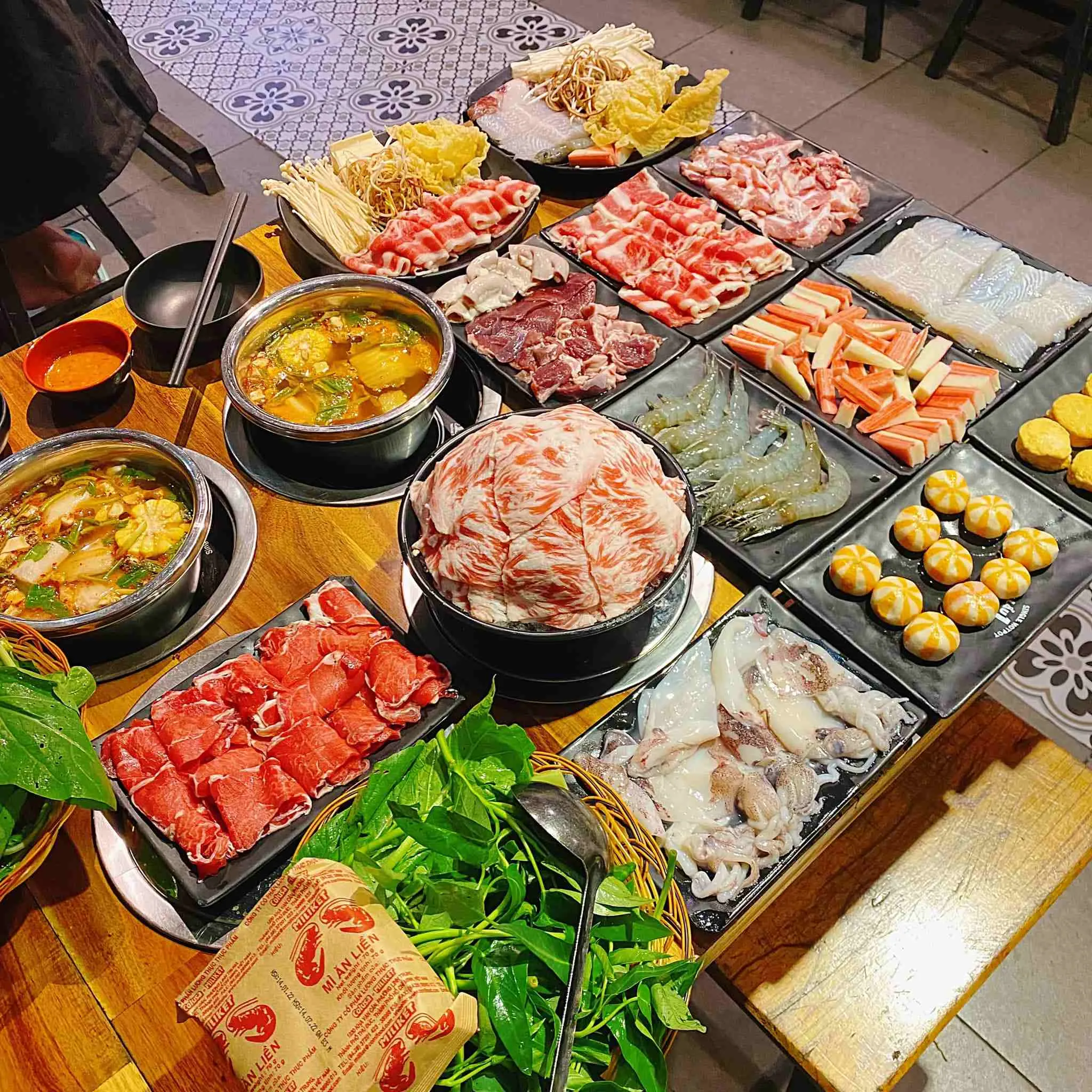 Một bàn đầy ắp các đồ nhúng lẩu tươi ngon