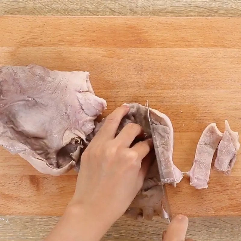 Cắt bao tử heo thành những miếng nhỏ vừa ăn sau khi luộc sơ