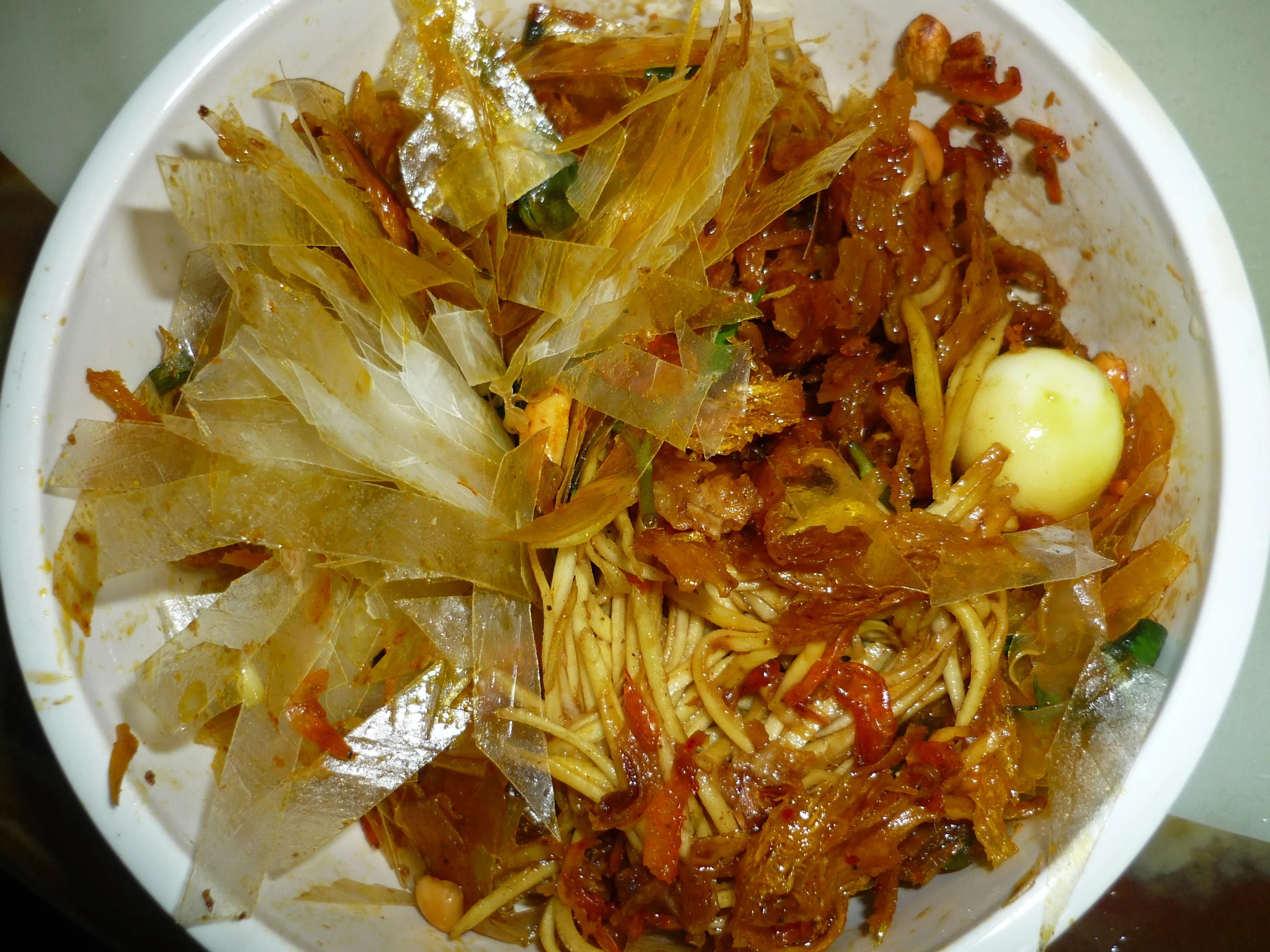 Bát bánh tráng trộn đầy ắp topping khô bò, trứng cút và xoài bào sợi thơm ngon.