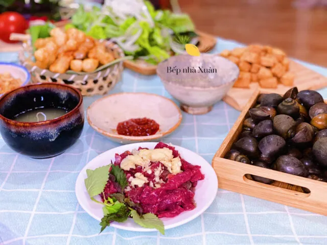 Một tô bún ốc Hà Nội nóng hổi, đầy đặn với ốc, đậu phụ và cà chua, kèm rau sống tươi ngon.