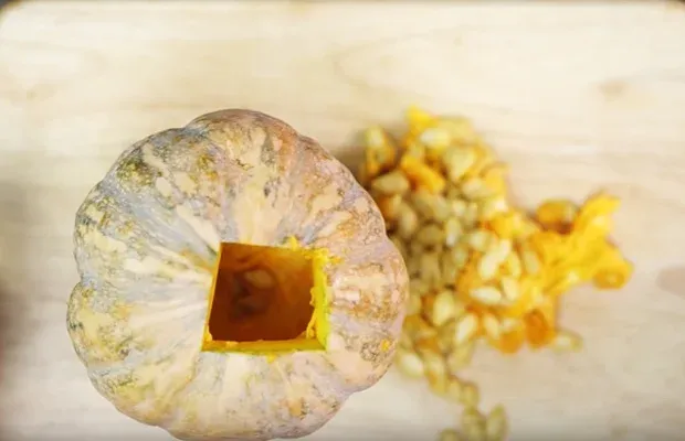 Mô tả cách múc bỏ phần ruột bên trong của quả bí đỏ tươi