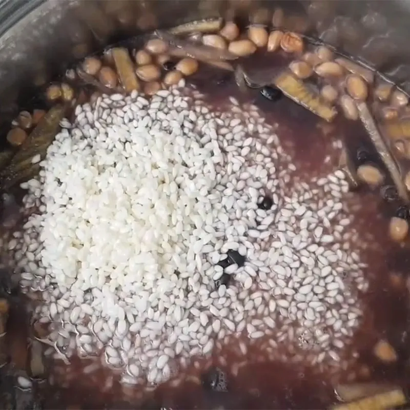 Thêm gạo nếp vào nồi sau khi khoai và đậu đã chín sơ