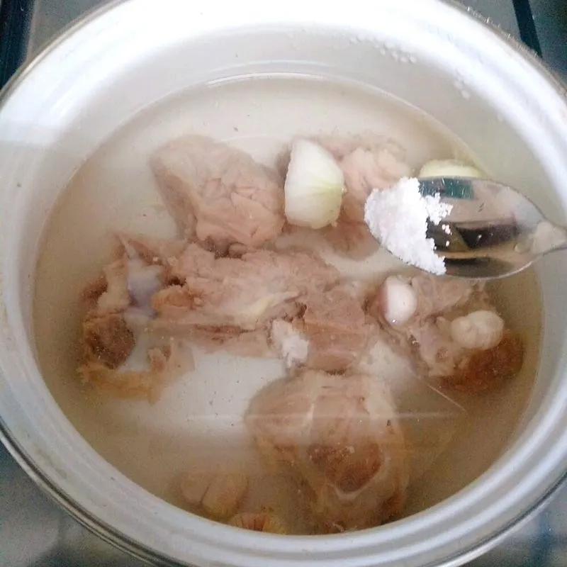 Thao tác thêm muối và hành tím giúp khử mùi và làm tăng vị ngọt thịt