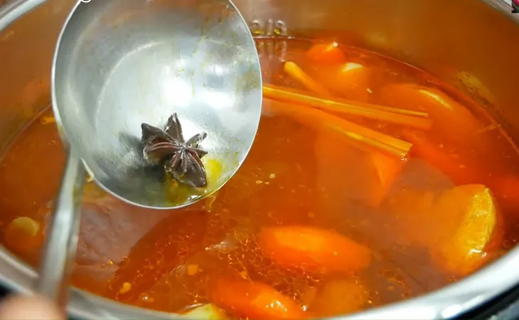 Nước dùng hủ tiếu sườn kho đang sôi, rau củ hòa quyện thơm ngon