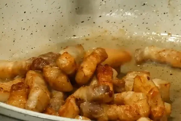 Thịt ba chỉ được rán vàng các mặt để tăng độ béo thơm cho món ốc chuối đậu