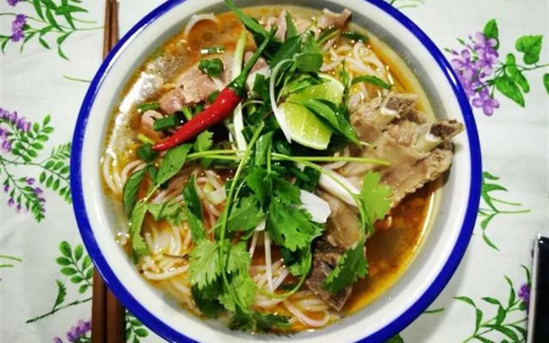 Bún bò tái với thịt bò mỏng và nước dùng trong