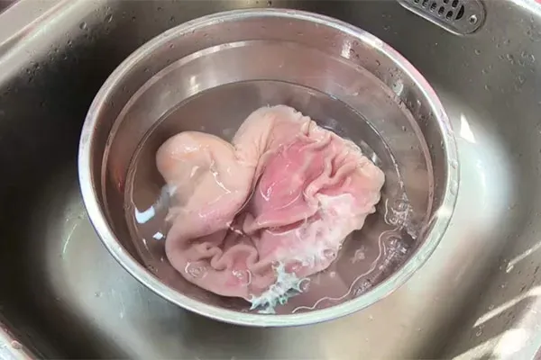 Quy trình chà xát bao tử heo với muối và chanh để làm sạch