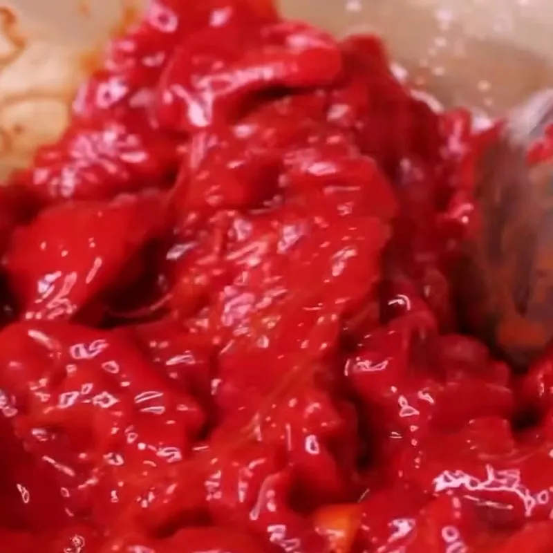 Trộn gấc vào nếp trong cách nấu xôi gấc với nước cốt dừa