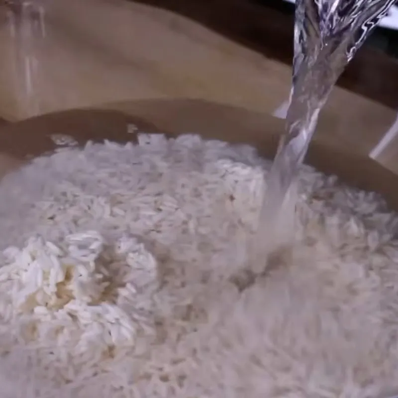 Sơ chế gạo nếp chuẩn bị cho cách nấu xôi gấc với nước cốt dừa