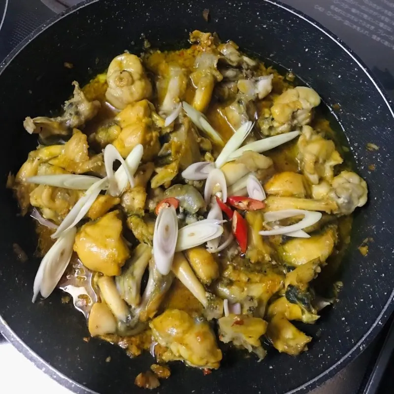 Thịt ếch và nước sốt sả ớt đang được đảo đều trên chảo nóng