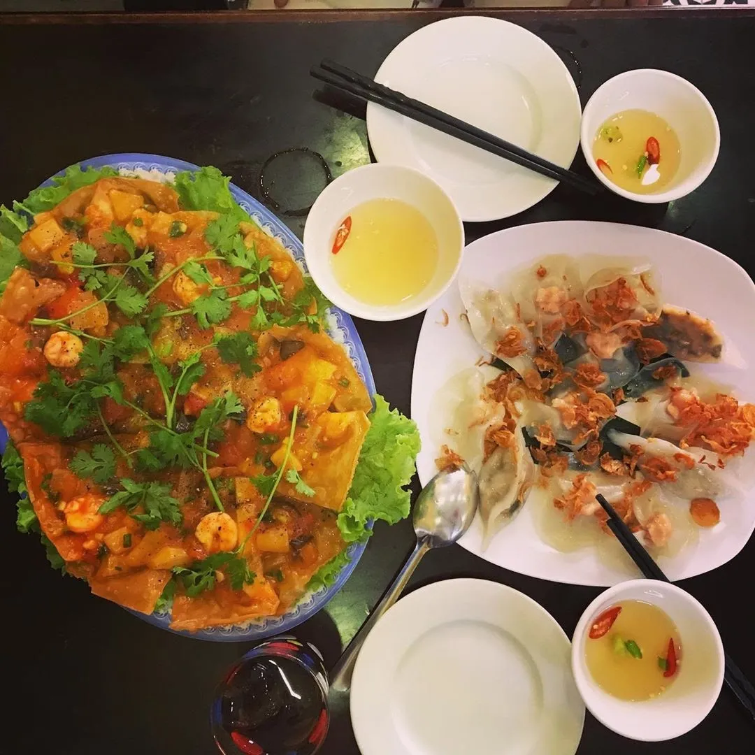 Đĩa bánh bao bánh vạc với nước dùng trong và hành phi