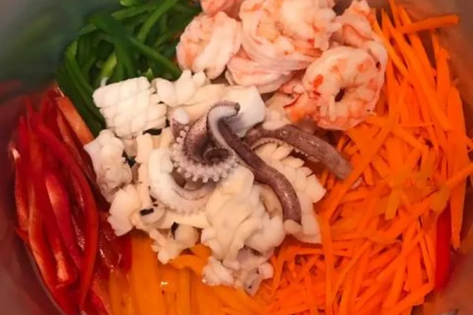 Thao tác trộn gỏi nhẹ tay để hải sản ngấm gia vị mà không bị nát