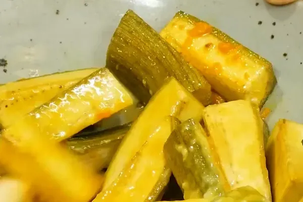 Trộn chuối xanh với nghệ và mẻ để ướp màu, chuẩn bị cho món ốc chuối đậu