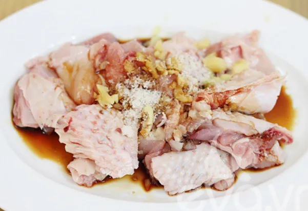 Ướp gia vị cho thịt gà trước khi nấu canh măng khô truyền thống