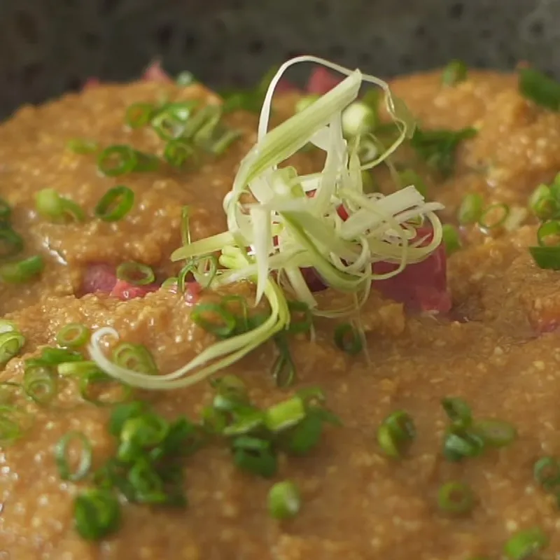 Rắc thêm hành lá và mè rang lên thịt bò đã ướp để tăng thêm hương vị