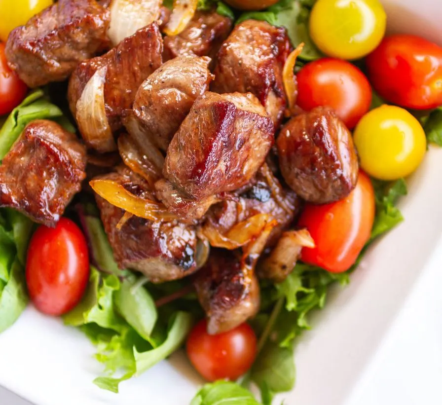 Bò Úc lúc lắc với miếng thịt vuông vức, màu nâu đẹp mắt trên đĩa salad